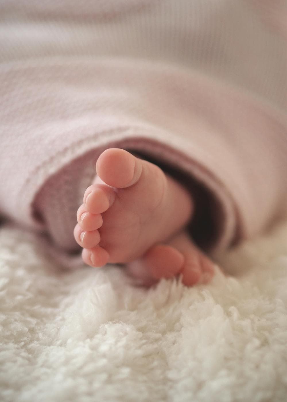 Newborn baby resting on a soft blanket