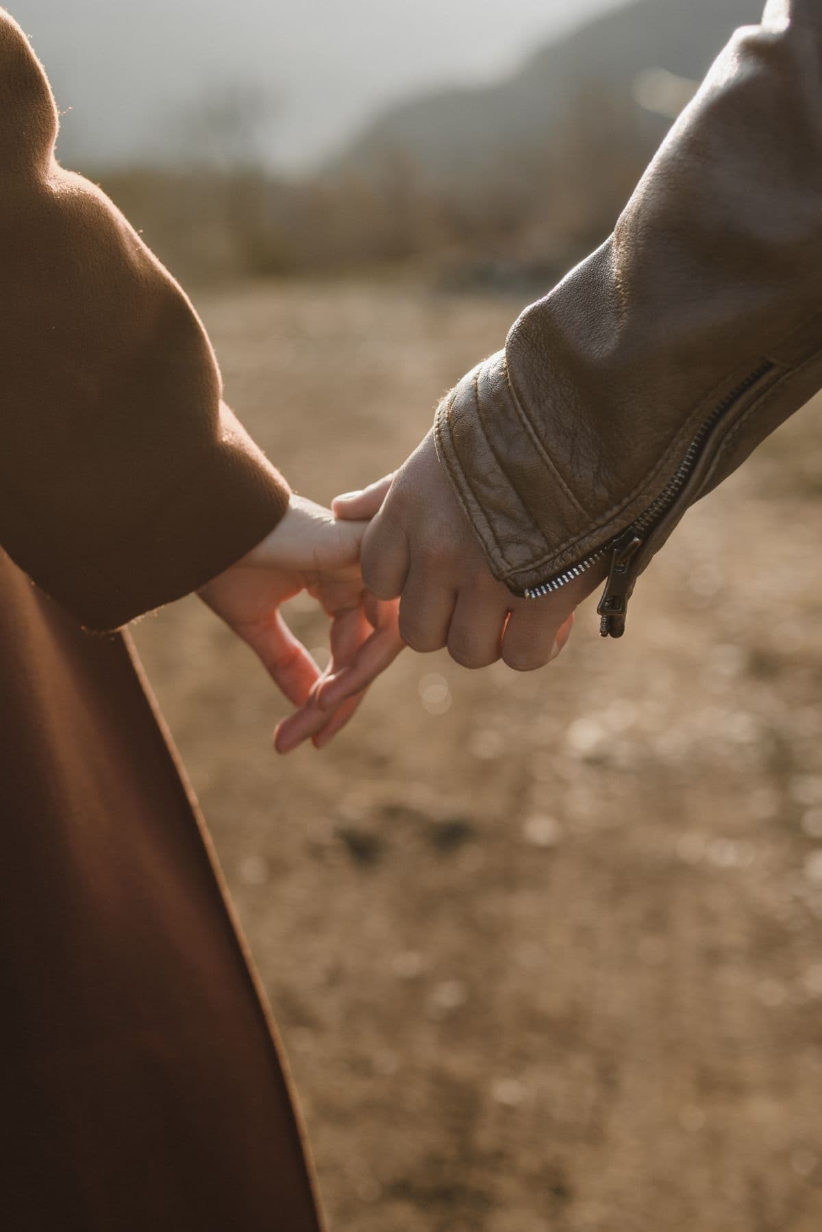Two hands almost touching against a warm background